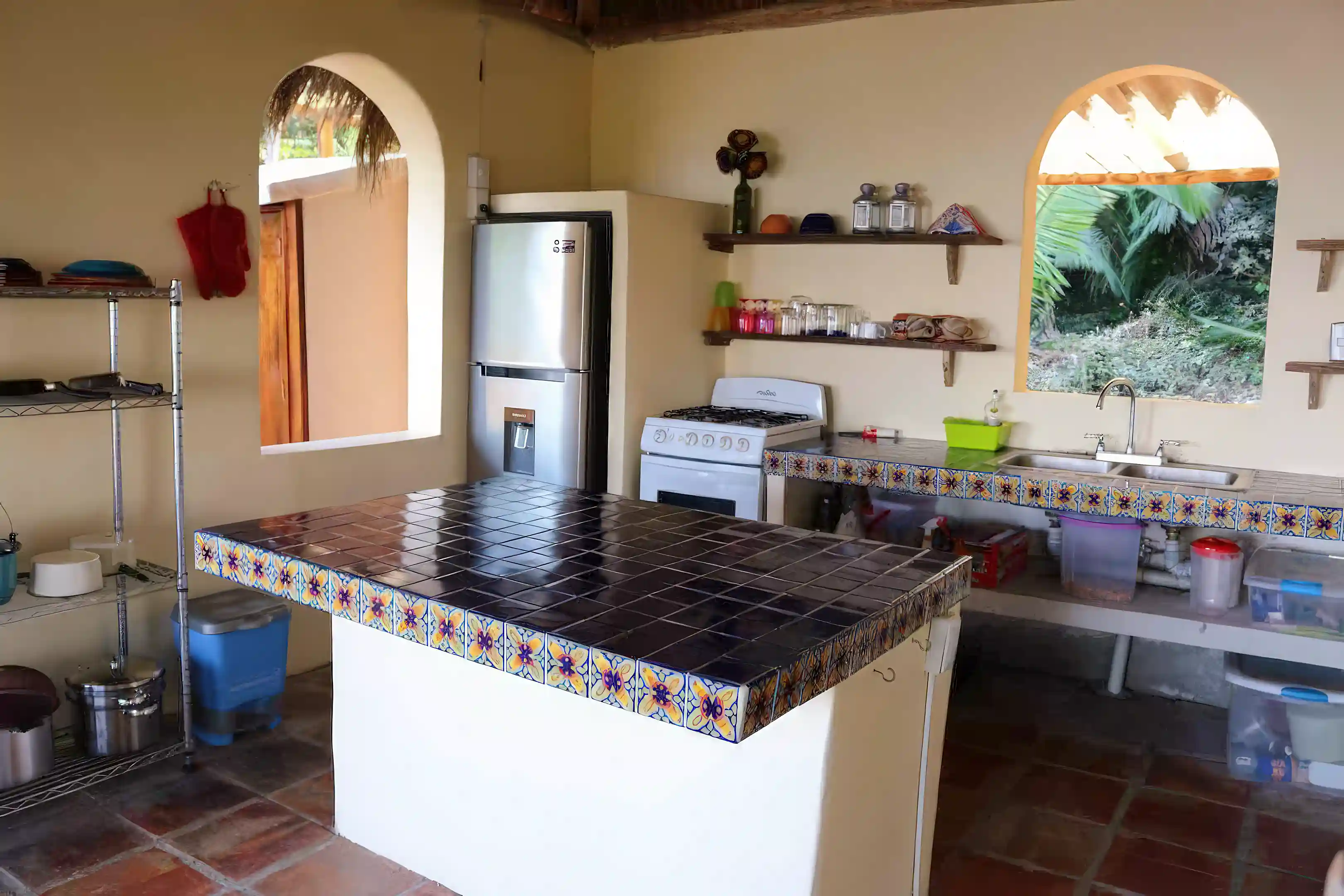Large kitchen island with storage shelves on one side, and...