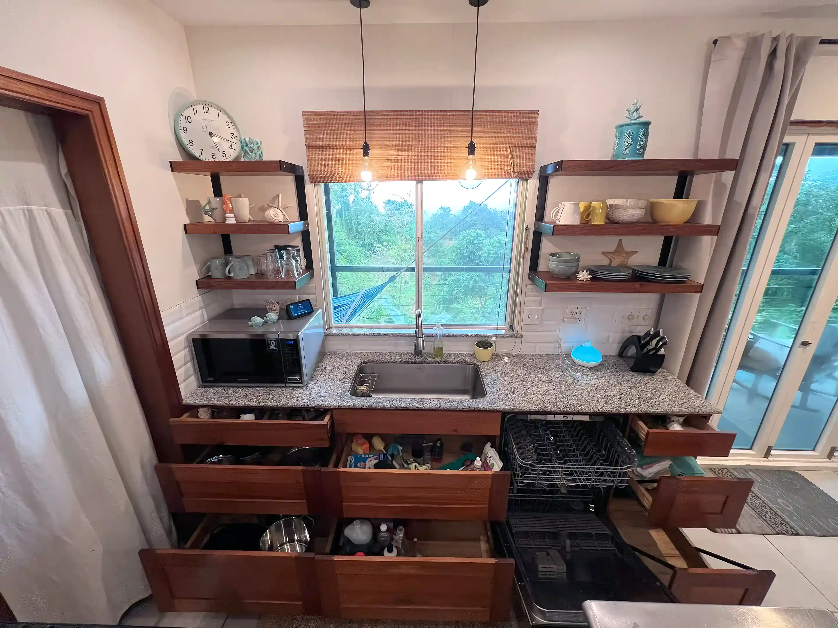 Straight-on view of kitchen with granite countertop, stainless steel sink,...