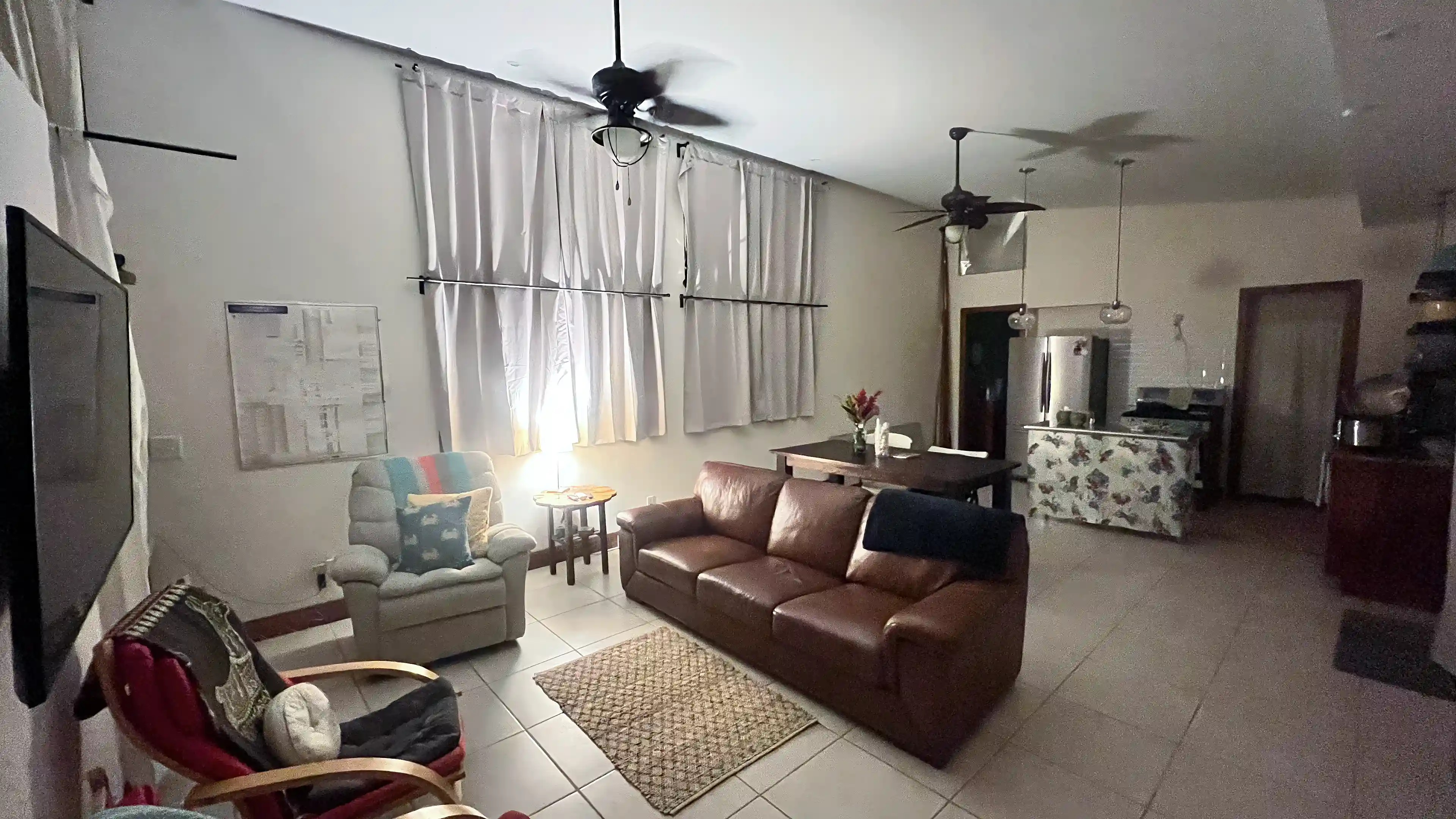 Warm nighttime view from the stairs showing the TV, recliner,...