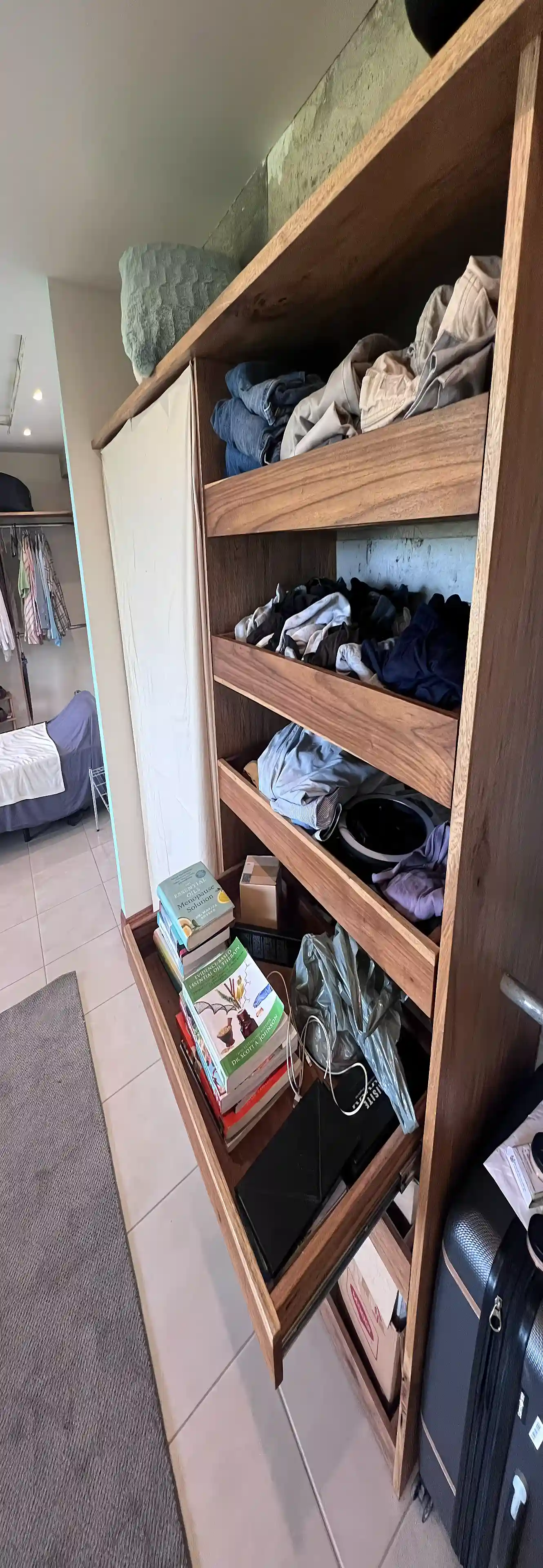 A close-up of the built-in closet reveals practical pull-out shelves,...
