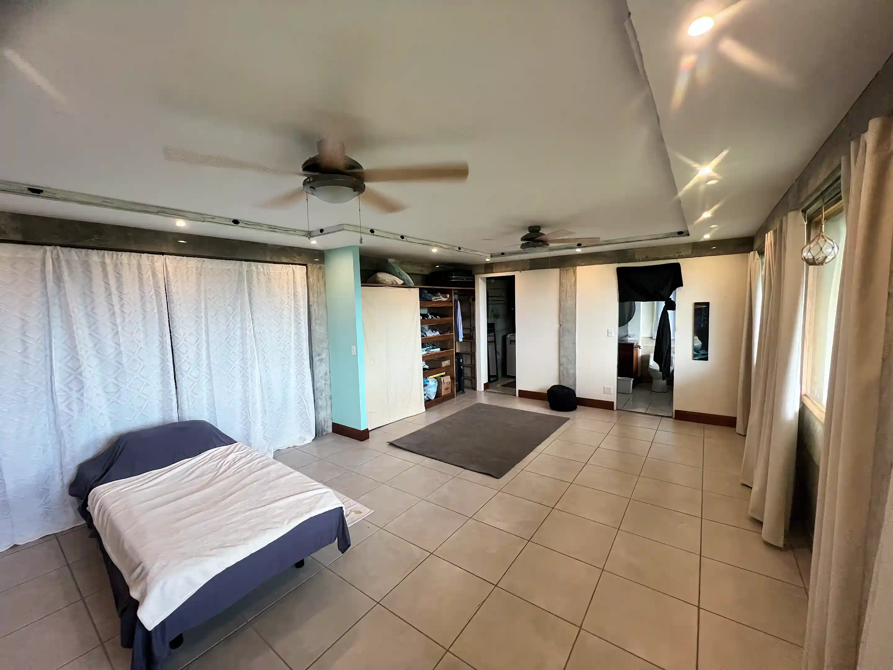 Oversized primary bedroom with three big sea-facing windows, coffered ceiling,...