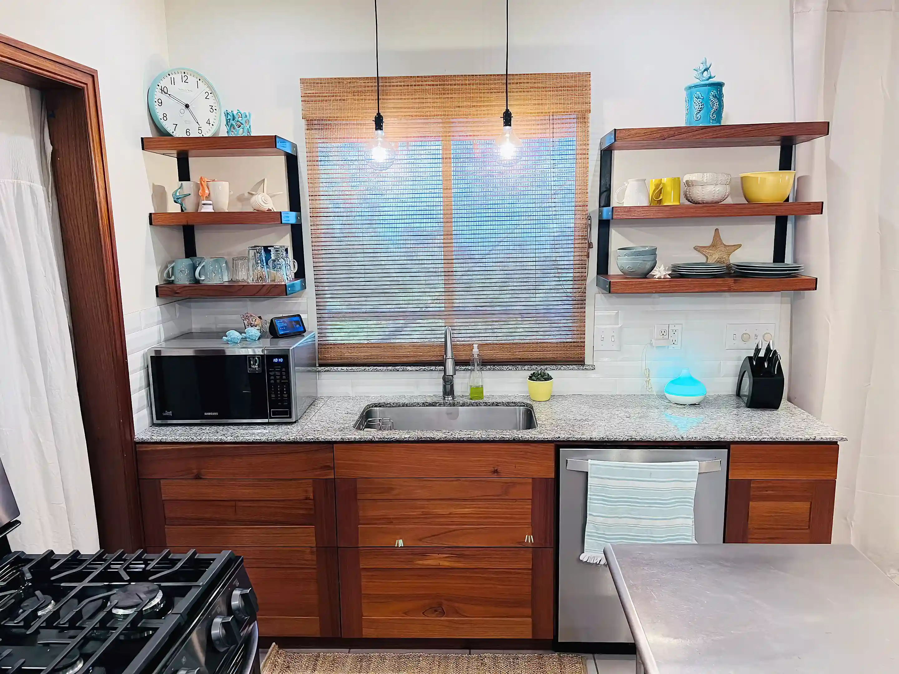 Straight-on view of kitchen with granite countertop, stainless steel sink,...