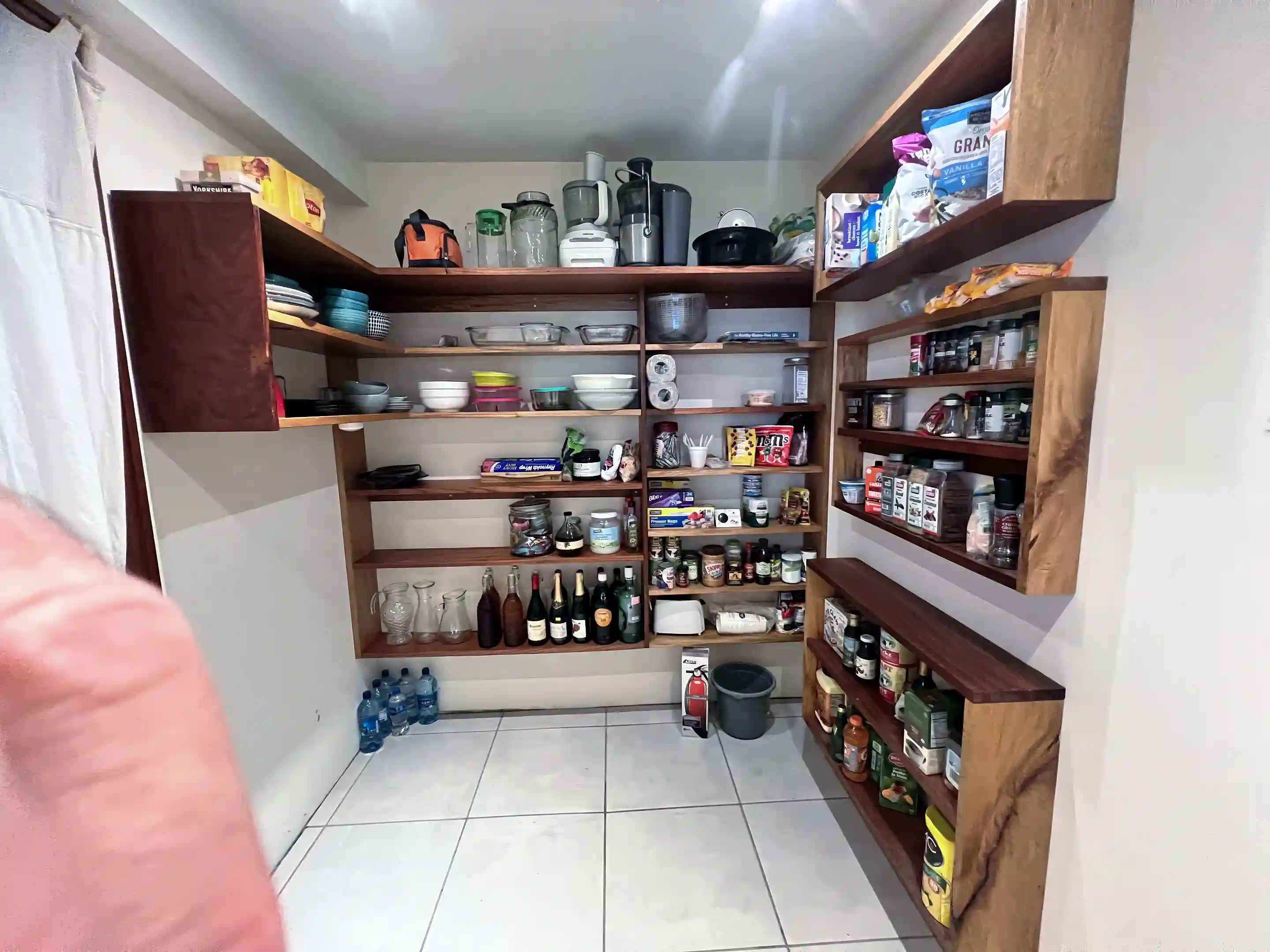 Bright, well-lit walk-in pantry with ample shelving for storage. Fully...