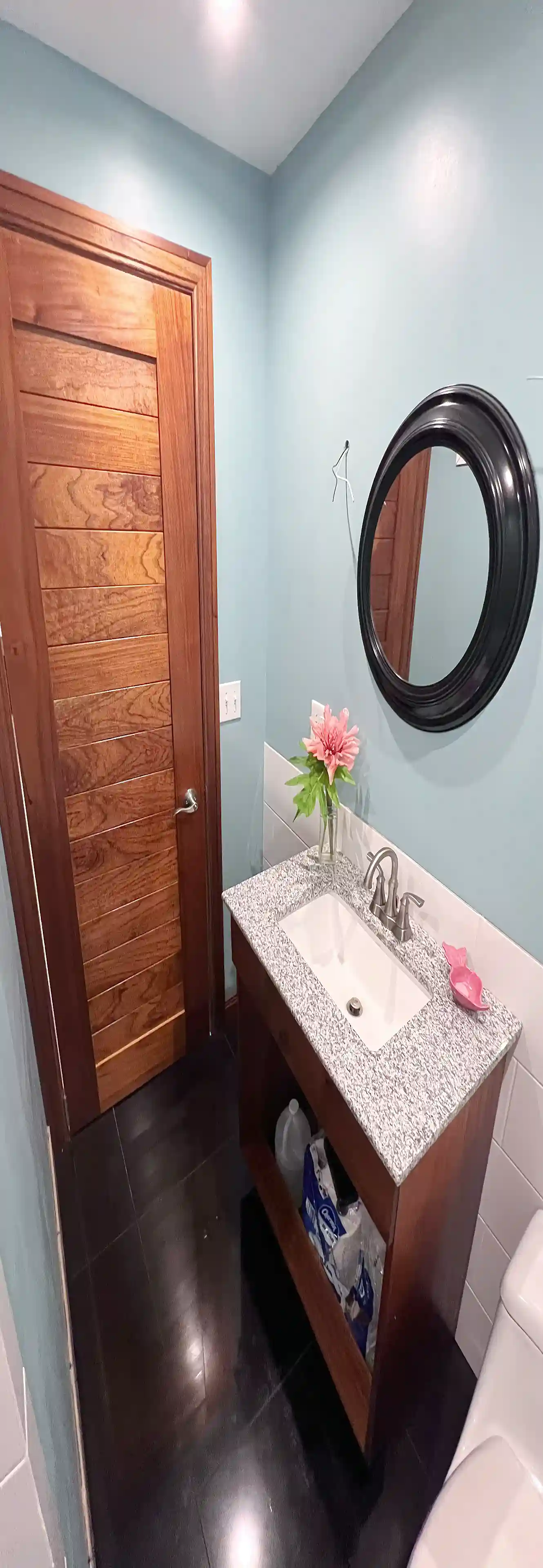 This elegant bathroom features a red cedar cabinet with a...